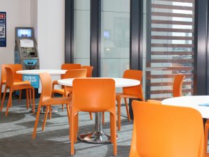 Southampton Central interior tables and orange chairs