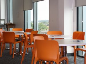 Southampton Central interior tables and orange chairs
