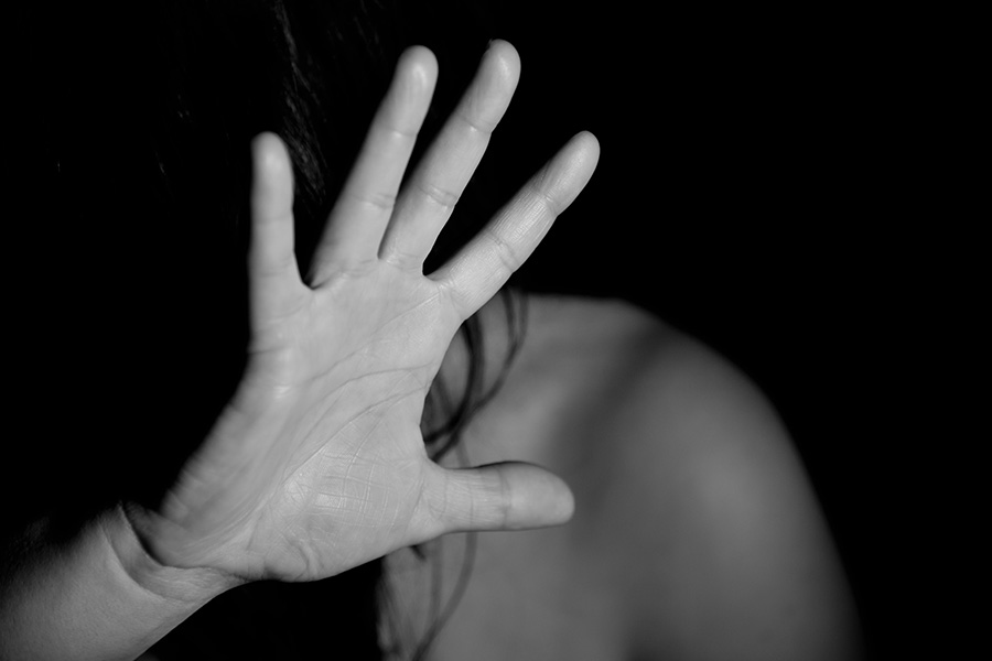 Domestic abuse; black and white photo of a hand held up