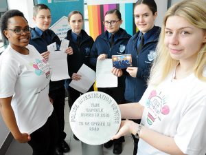 Youth Commission members and police cadets holding the cover of the time capsule