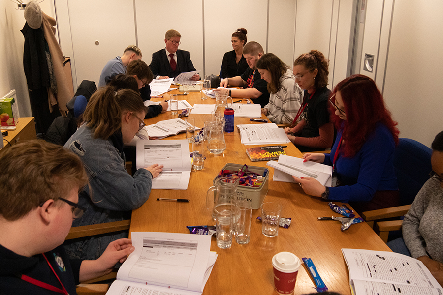 View along a conference table at CPS Wessex, where 10 Youth Commission members are sitting with two officers from the CPS at the far end.