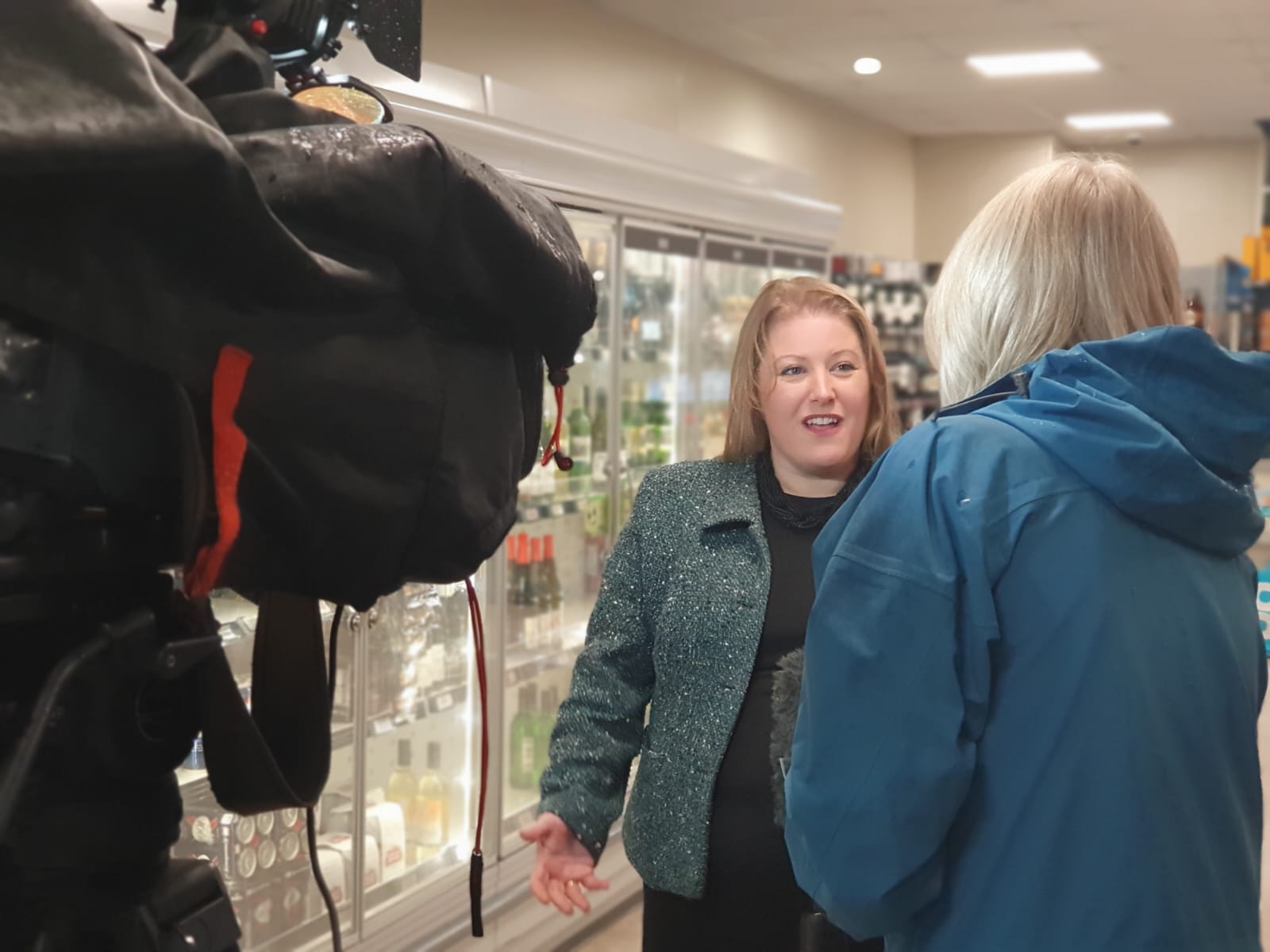 Donna Jones speaking to TV cameras inside a co-op