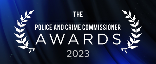 Logo for the police and crime commissioner awards 2023 in white featuring on a blue curtain background