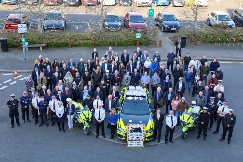 A marked police car with a large number of people gathered all around it including PCC Donna Jones and Chief Constable Alexis Boon.