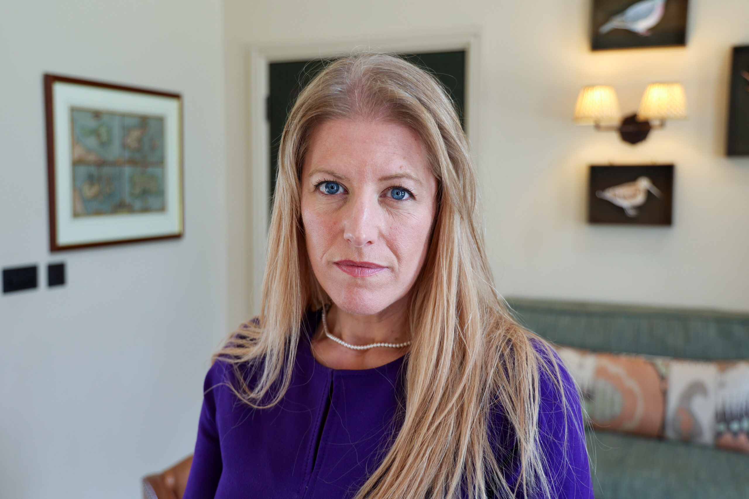 Police and Crime Commissioner Donna Jones with a serious expression. Donna is wearing a purple top and is stood in an elegant room.