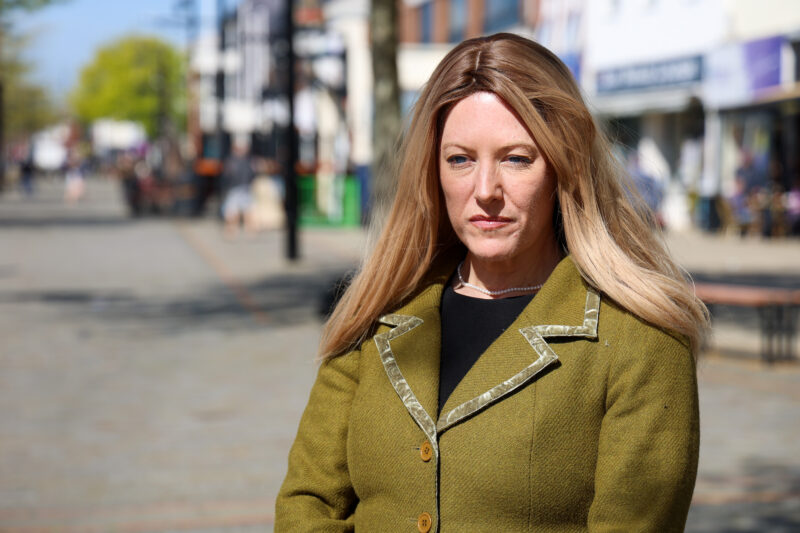 PCC Donna Jones with a serious look on her face. She is in a High Street wearing a green jacket.,