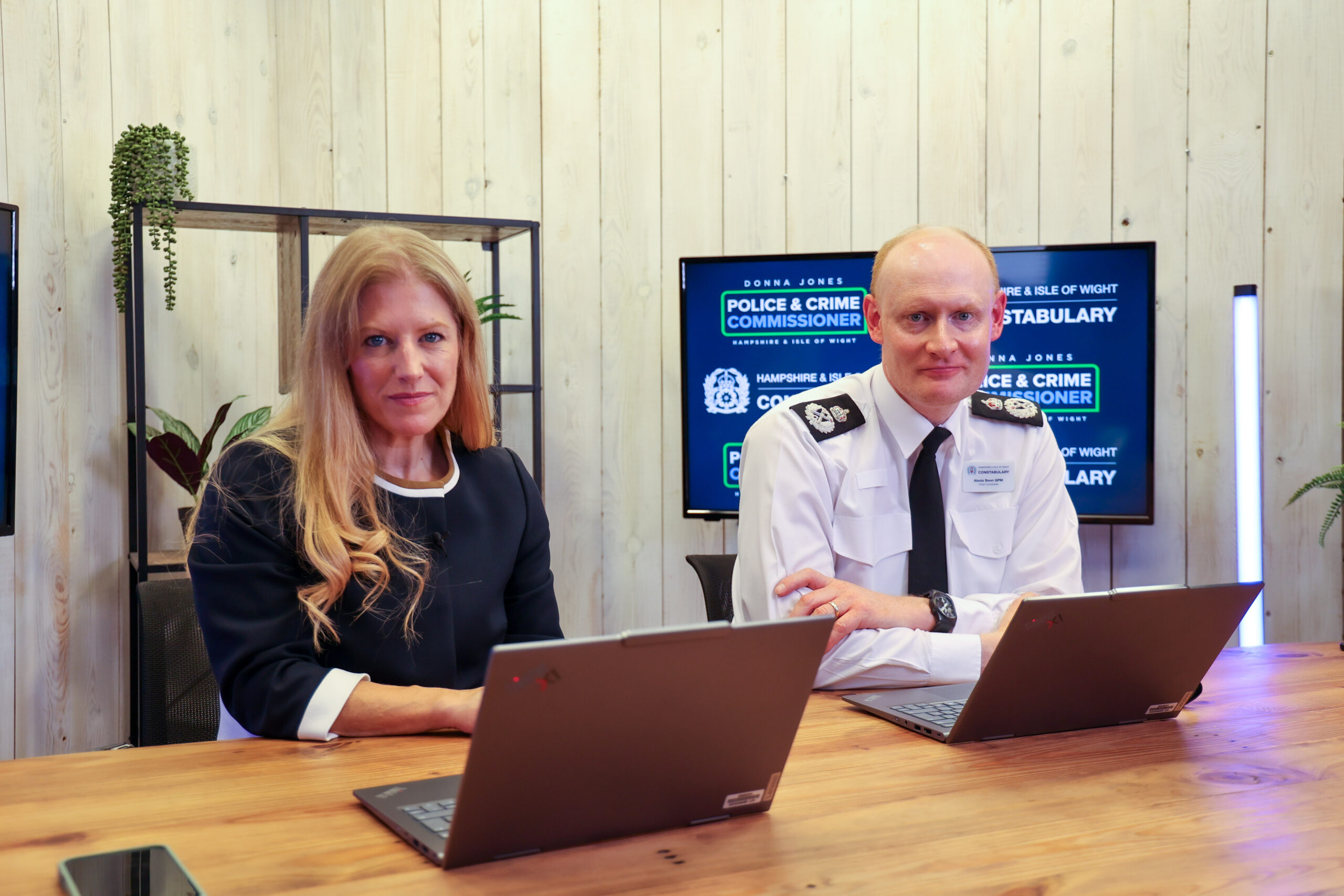 PCC Donna Jones and the Chief Constable sit at a desk with laptops