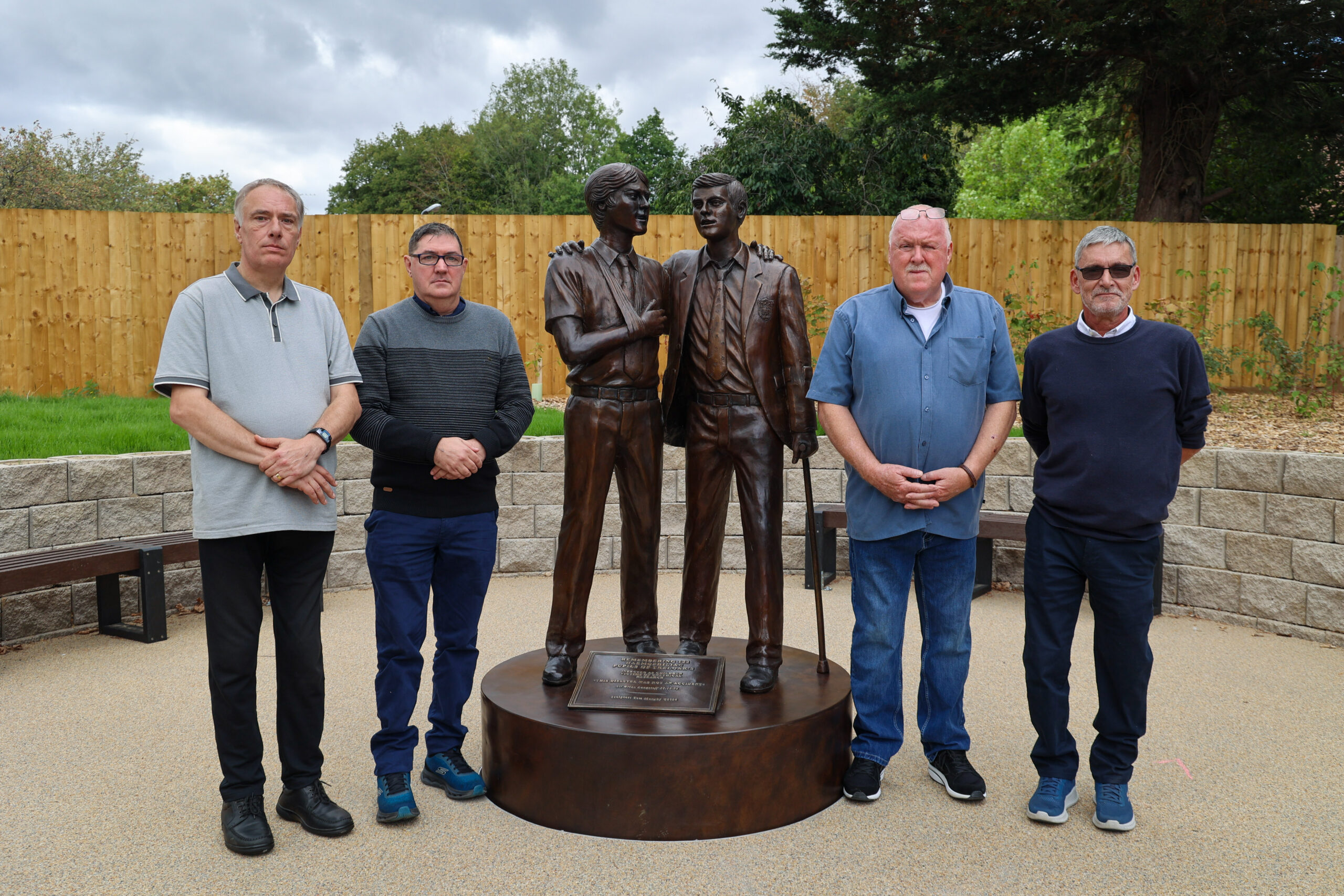 Richard Warwick, Adrian Goodyear, Steve Nicholls and Gary Webster standing next to the Treloar's memorial.